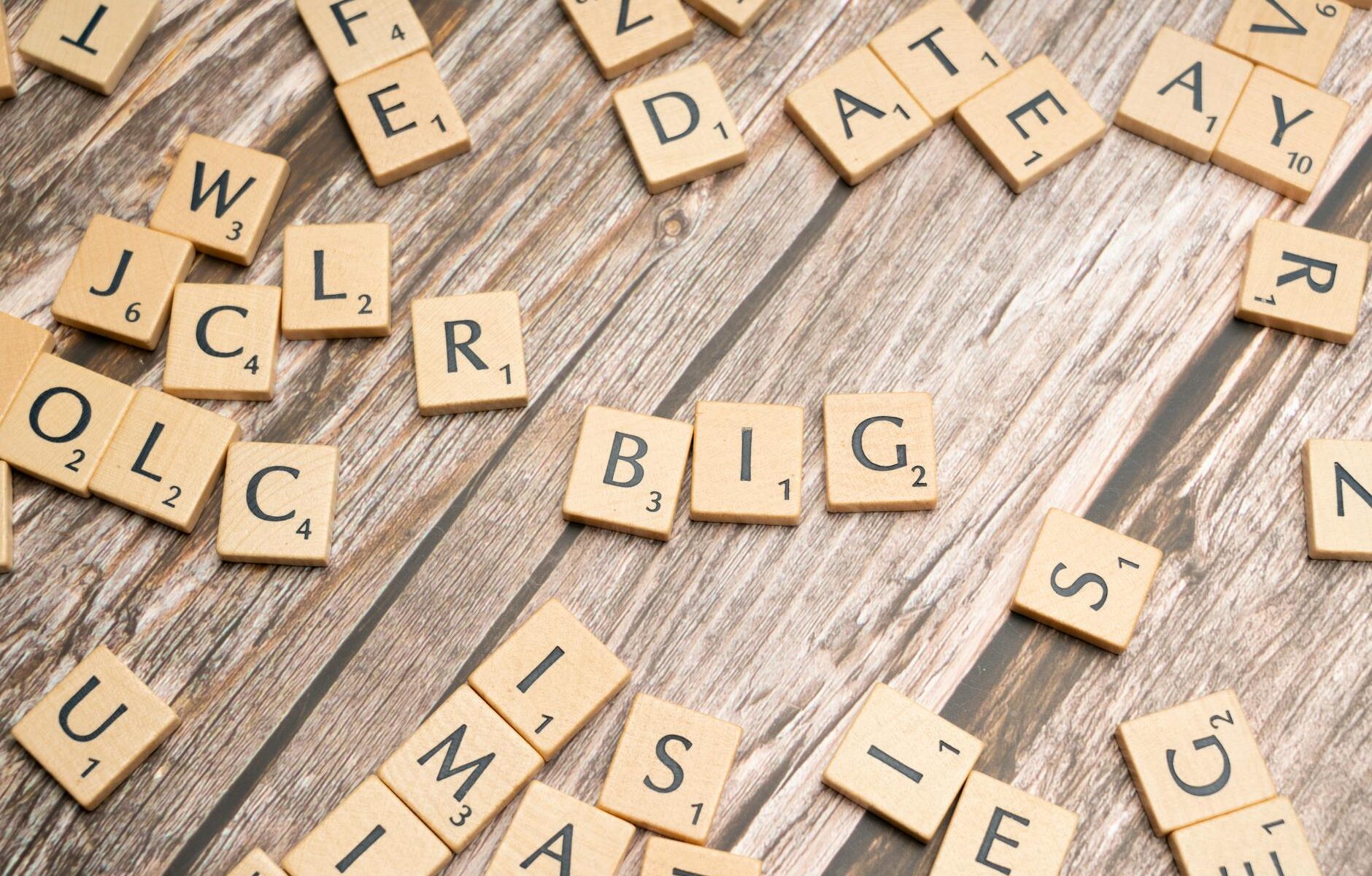 scrabble letters spelling big on a wooden table